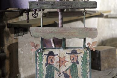 Enseigne ancienne peinte montrant deux personnages encadrant une étoile, avec l’inscription « À l’enseigne des bons enfants ».