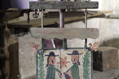 Enseigne ancienne peinte montrant deux personnages encadrant une étoile, avec l’inscription « À l’enseigne des bons enfants ». - Agrandir l'image 1 sur 8, fenêtre modale