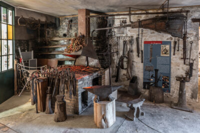 un atelier de type forge avec plusieurs outils anciens comme des enclumes ou des pinces de couleur marron - Agrandir l'image 5 sur 6, fenêtre modale